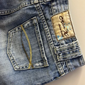 LÅGMIDJAD JEANSKJOL - Supersnygg lågmidjad vintagekjol från Cron X! Verkligen så snygg färg och modell🙏🏽Den är dessutom i väldigt bra skick, inga fläckar, hål, etc💕💕  Midja: 38cm Längd:28cm Höft:44cm