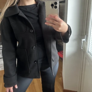 svart kort jacka - svart kort kappjacka. aldrig använd, vet tyvärr inte vart den kommer ifrån då jag köpte den oanvänd av en annan tjej.