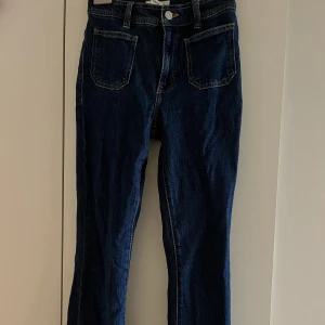 Blåa bootcutjeans med fickor - Mörkblåa bootcut jeans med synliga framfickor.  Storlek 32 (passar 34) Från mango 