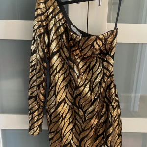 Paljettklänning guld/svart - Supercool paljettklänning perfekt till höstens/vinterns fester! 