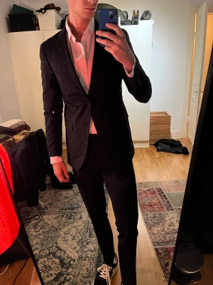Svart Kavaj från Sand Copenhagen - Säljer denna klassiska svarta kavaj från Sand Copenhagen. Tillverkad med omsorg i Italien och avspeglar europeiskt hantverk och design. Perfekt för dig som uppskattar kvalitet även i välanvända kläder. Passa på att göra ett smart och hållbart val!