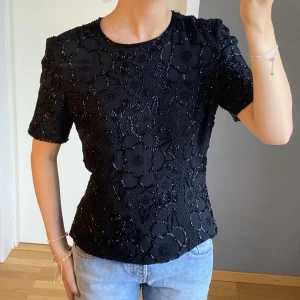 Topp med pärlor  - Svart topp med ”pärlor” i blommönster, storlek M 🌟😇