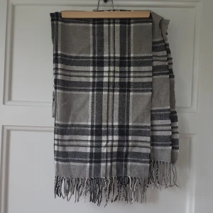 Stor mysig halsduk i gråa nyanser - Otroligt mysig halsduk som är stor, ser inte stor ut runt halsen men går att vira runt sig som en filt. Tror att den kommer från Åhlens men ej säker. 