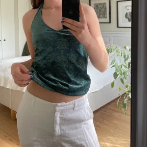 Halterneck topp - Unik halternecktopp köpt second hand. Den är mörkgrön i färgen med ett gulligt mönster. Sitter bra på sig som har S, men eftersom man knyter den i nacken så kan den passa större och mindre storlekar också! Jättefint skick 🧡
