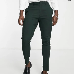 Gröna kostymbyxor - Helt nya, oanvända ”skogsgröna supersmala kostymbyxor med mikrotextur” från ASOS. Säljes eftersom jag missade returen och säljer även kostymbyxorna i annan annons. Har kvar påsen de skickades i och lappen sitter kvar. Nypris 499