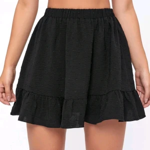 Mönstrad sommarkjol. - Stretchig, kort, luftig svart kjol med små mönster.