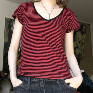 Randig kortärmad tröja  - En svart och rödrandig kortärmad tröja med större urringning 