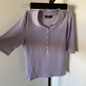 T-shirt med krage - en lila ribbad T-shirt med krage och knappar. aldrig använd!