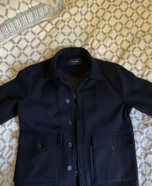 A Days March Marinblå Overshirt. - En marinblå overshirt från a Days march. I gott skick med 65:35 bomull polyester med linning i viskos. Passar perfekt som sommarjacka.   Storlek: S  Märke: A Days March  Nypris 1400 men vid snabb affär släpper jag den för 600. 