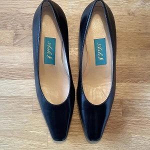 Låga svarta klackar - Säljer ett par oanvända klackar i storlek 35. Svarta glansiga i original förpackning. Tillverkade i Italien. Originalpriset är ca 1200kr. Gjorda av läder och ungefär 5 cm klackhöjd. Skriv dm för frågor.