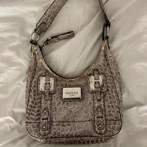 Guessväska  - Medelstor guess väska i brun/beige ormskinn med silverdetaljer👜