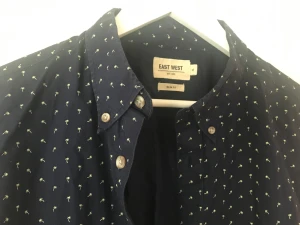 Skjorta  - Slimfit skjorta från Brothers och marinblå skjorta full av små palmer i en fin gul färg. Materialet är tunt snyggt tyg. Inga defekter eller dylikt.  Skriv gärna om ni har frågor.  Köpa fler lika med bättre priser !  Köparen står för frakten  