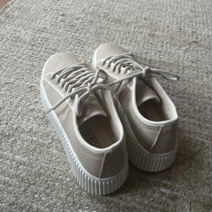 Sneakers  - Helt nya bowser sneakers i färgen beige från Nly By Nelly, storlek 36. Säljer då det är för små och inte går att returnera längre. Ny pris 500kr, mitt pris 450, men kan även tänka mig diskutera. Hör av dig vid frågor. (Frakten stämmer ej!!) 