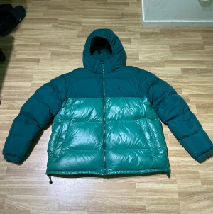 Grön Adidas puffer Jacka - Säljer min gröna Adidas pufferjacka eftersom jag rensar ut min garderob och den används inte.  Storlek L tror jag (80/20 står det i jackan) Har används ett få tal gånger. Den köptes förra året för 2299kr.  Priset kan diskuteras vid snabb affär. 