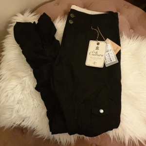 Helt nya byxor - Storlek 38/M lapparna kvar. En blandning av chinos/cargo byxor. Lite lösare passform med tajtare benslut. Fickor med knappar på baksidan. As cool modell men tyvärr för långa på mig (158) Nypris 599:- 