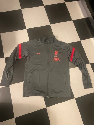 Liverpool träningsoverall  - Säljer en grå Liverpool träningsoverall pga för liten. Storlek S, används ett fåtal gånger. Skriv för fler bilder 😊 pris kan diskuteras! 