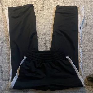 Trackpants - Träningsbyxor från Sport zone köpa second hand, inga tydliga defekter och de har både snörning i midjan och dragkedja längst ner i benen, använd köp nu <3