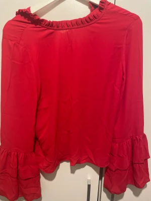Röd blus - Röd blus frn Gina Tricot, storlek 34 (motsvarar nog Xs, i jätte bra skick, har volang ärmar, skriv för mer information 
