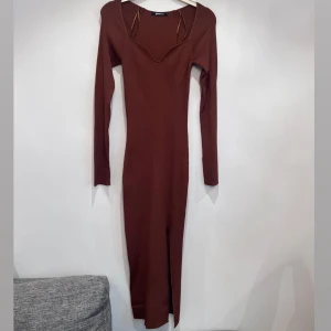 Klänning  -  Fiona knitted dress. Stickad klänning med slits i sidan. Den har en midilängd, hjärtformad ringning, figurnära passform och långa ärmar med slits vid ärmsluten. 