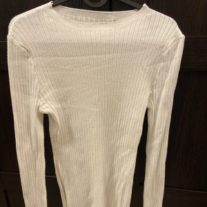 Vit ribbad tröja med slits - Lappen är borttagen. På sidorna har tröjan slitsar som både är en fin detalj, men också som framhäver formerna enligt mig. Den är använd typ en gång bara eftersom att jag glömde bort att jag hade den. Fick sjukt många komplimanger för den under dagen!?