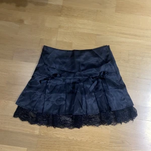 Svart kjol med spets och rosetter - Storlek S. Säljer då den tyvärr inte kommer till användning längre. Jättefin spets och gullig rosett-detalj. För fler bilder/info skriv i DM😇💓