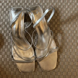 Klackskor - Asballa silvriga klackskor från H&M fint skick syns lite spår av användning, går kanske att tvätta bort men mest på sulan så inget som syns på. Klackar ca. 5 cm.