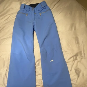 J lindberg skidbyxor - Säljer dessa supersnygga klarblå j lindberg skidbyxor i väldigt fint skick. Inga fläckar eller liknande men har små revor längst ner bak på byxan. Syns på sista bilden💕Skriv vid fler frågor! Storlek small, långa på mig som är 165 när jag har pjäxor.