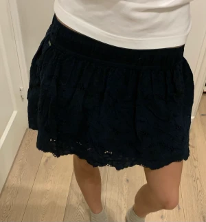 Hollister Minikjol - Säljer min super söta spets kjol från Hollister då den blivit för liten.🥹Storlek S men skulle säga att den passar XS bättre💕