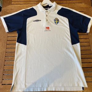 Sverige piqé (retro) - Detta är en piqé från svenska fotbollslandslaget. Den är troligast ifrån 2004 men kan även vara senare. Men en sak är säker och det är att den är ifrån den tid då Zlatan spela.  Skick:  