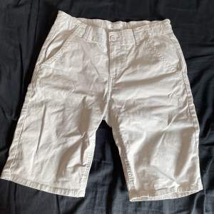 Dessa beiga shorts från Lindex är i storlek EUR 170, 53 cm långa och 34 cm i midjan. De är helt oanvända och i utmärkt skick. De har en klassisk stil och har fickor både fram och bak. Säljer då jag aldrig använder de. Hör av er med frågor och pris.