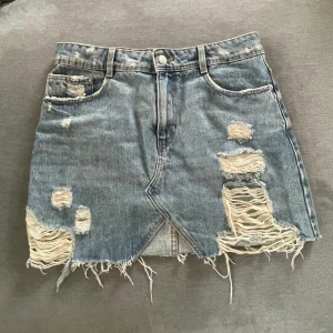 Jeanskjol  - Normal i storleken. Ska vara sliten. 