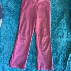 Byxor  - Rosa utsvängda byxor i bra skick. 