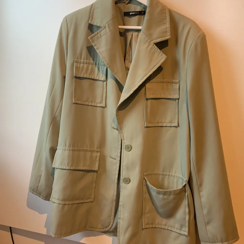 Militärgrön jacka med fickor och knappar. Är större i storlek.. Jackor.