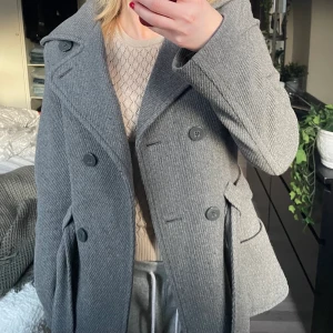 Grå kappa! - Heej! Säljer denna så fina gråa lite kortare kappa med ”snöre” runt. Perfekt nu till våren-inte för tjock men inte för tunn. Storlek 36 men skulle säga att den passar 34 också. Säljer för att jag har för många kappor💞👌🏼