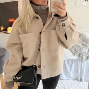 Beige kort kappa  - Säljer denna beige kappan från NA-KD då den inte kommer till användning. Bra skick, som ny. Köpte för 699kr säljer för 450kr. Frakt tillkommer❤️