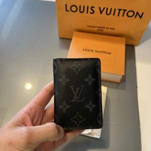WTS  Louis Vuitton Pocket Organiser Monogram Eclipse Canvas  Bin 3400kr  Köpt på Louis Vuitton Stockholm för cirka 2-3 år sedan, använd sparsamt.
