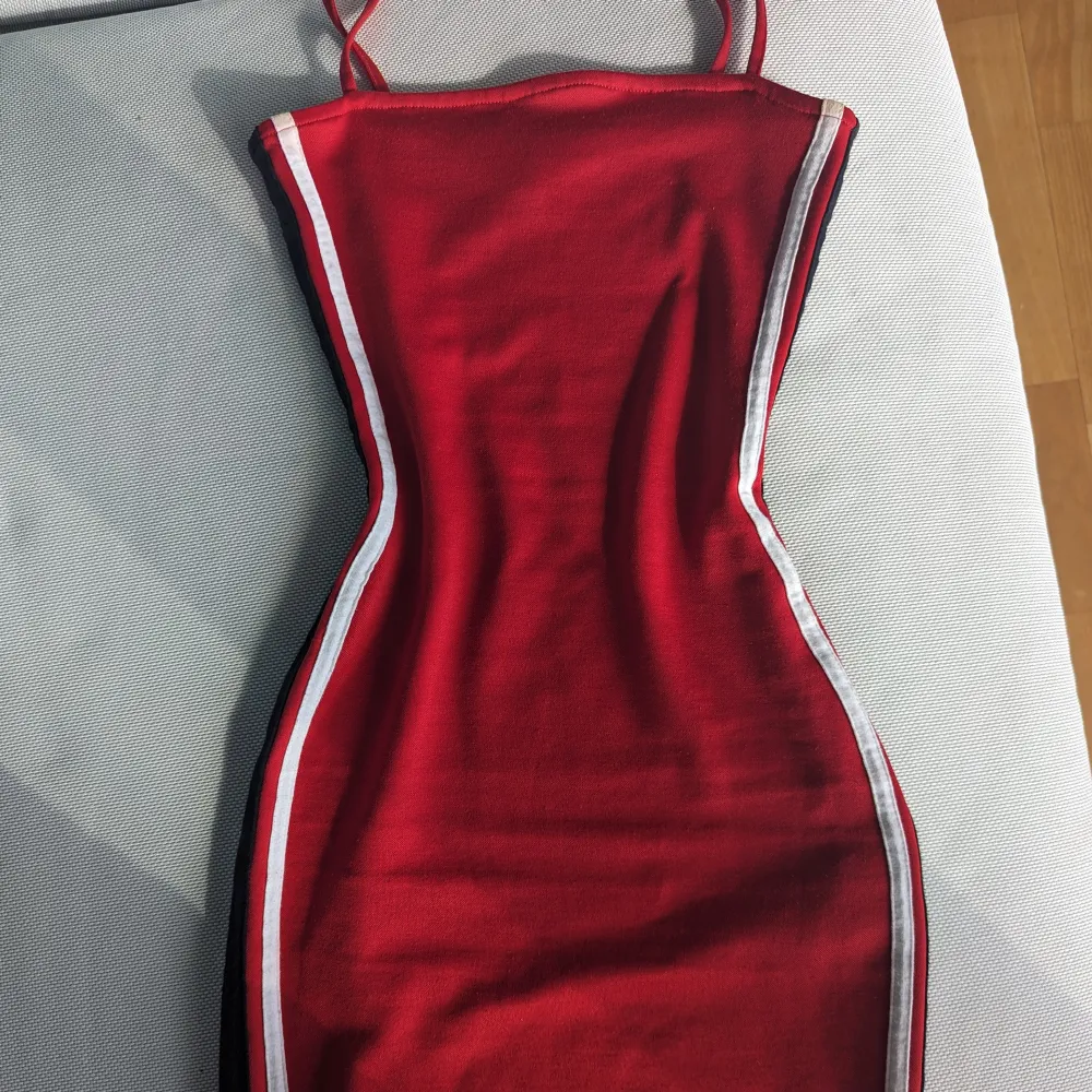 Säljer denna jättefina röda klänningen eftersom den är för liten för mig nu. Den är väldigt kort och har stretchig tyg som sitter tajt och bekvämt på kroppen på ett väldigt smickrande sätt! Den är dessutom i bra skick. Klänningar.