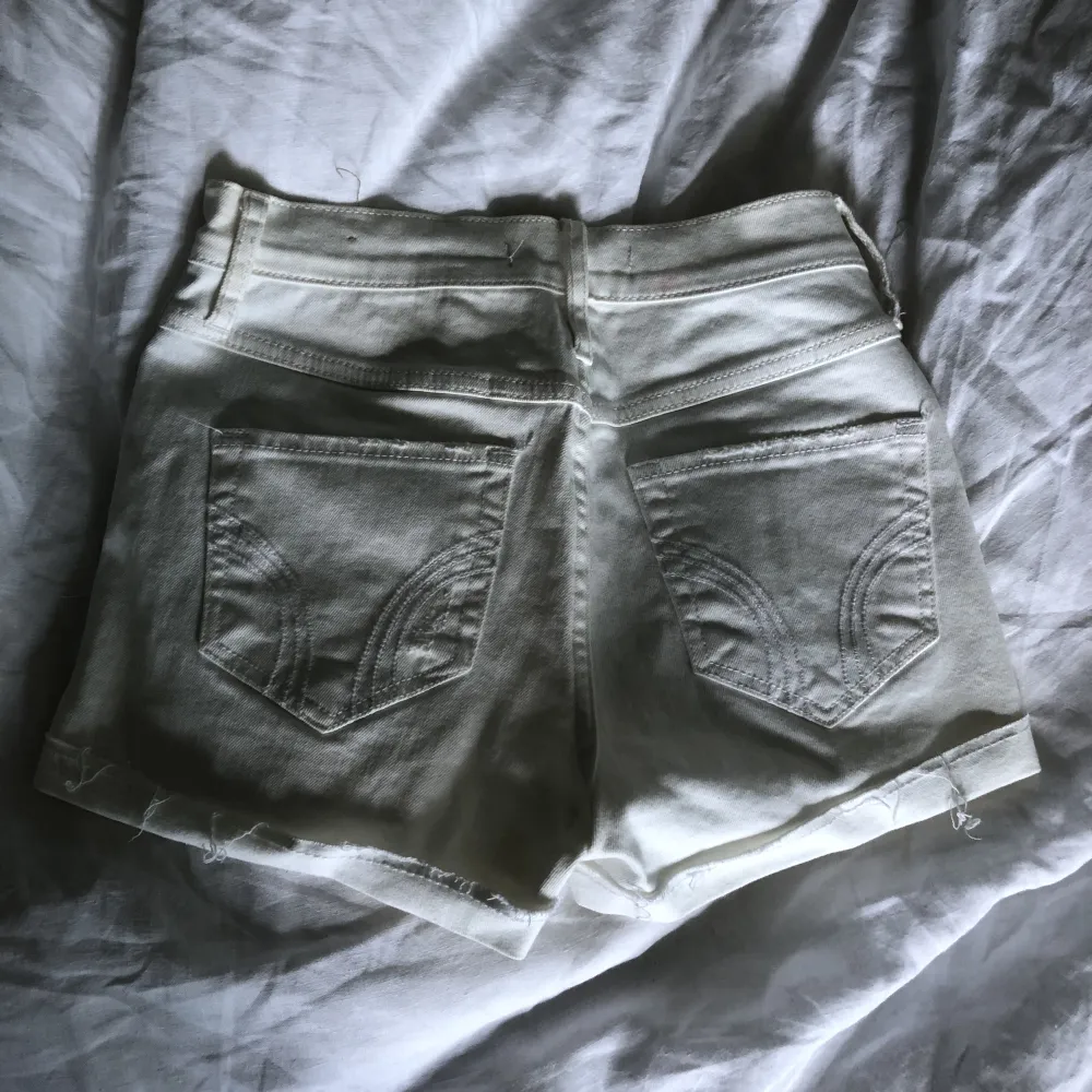 Högmidjade jeansshorts i vitt och lite slitningar från Hollister i storlek w24.. Shorts.