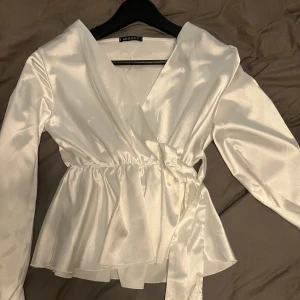 Blus - En vit blus i satin, helt oanvänd. 