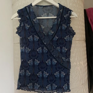 Blå Mech topp med mönster - Mech topp med fin läge på armarna. Endast mech på ryggen vilket gör toppen väldigt fin. 