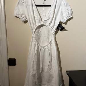 Jättefin vit klänning med öppning på magen för en extra detalj. Sitter jättefint på kroppen. Aldrig använd och prislapp finns därför kvar. Priv för frågor💗