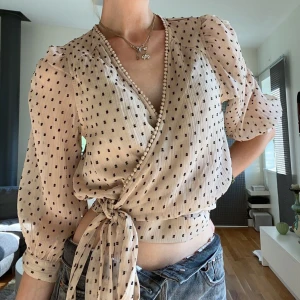 Blus med knyte - Super söt blus med knyte i midjan. Rosa/beige med svarta prickar. Helt oanvänd och i nyskick