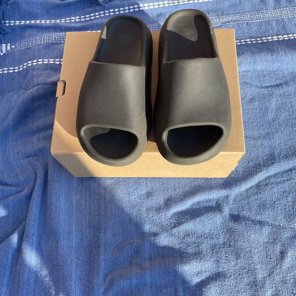 Ett par knappt använda yeezy slides skick 9/10. Nypris 2000 kr, de är väldigt väldigt sköna och är perfekta tofflor till sommaren. Kvitto finns. Fler bilder finns. Skor.