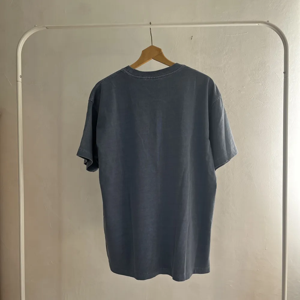 En sprillans ny carhartt tshirt med orginallapparna kvar i urtvättad blå färg. Storlek medium men sitter lite oversized. Storlek Medium. T-shirts.