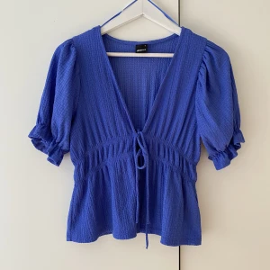 Gullig topp - Så fin topp från Gina, men som inte kommer till användning. Bara använd 1 gång, nyskick. Blå/lila färg.