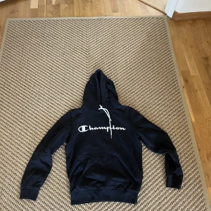 Hoodie svart Champion  - En tröja som är varsamt använt och inte har några tecken på användning. Skön tröja som sitter lite overzised, säljer pga av att den är för liten. 
