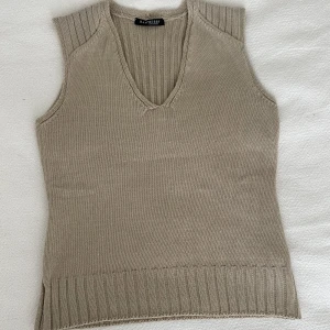 beige väst - En jättefin och skön väst som är ribbad på ryggen. Är i ett väldigt behagligt material och en fin beige färg som passar till det mesta! Har en liten y2k känsla om man stylar den med lågmidjat men funkar såklart till vad som helst:)