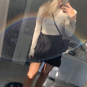 Volangkjol - Svart volangkjol med rosett i ena sidan, från Gina tricot i strl S.