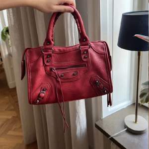 Säljer vidare denna röda Balenciaga liknande väska i bra skick. Spår bar frakt som köparen står för.