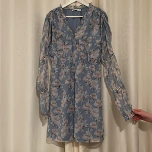 Blå blommigklänning från NAKD - Säljer denna jätte fina blå blommigaklänningen som är perfekt till massa tillfällen, har prislapp kvar. Pris går att diskuteras. Kan mötas vid diskuteras plats ❣️